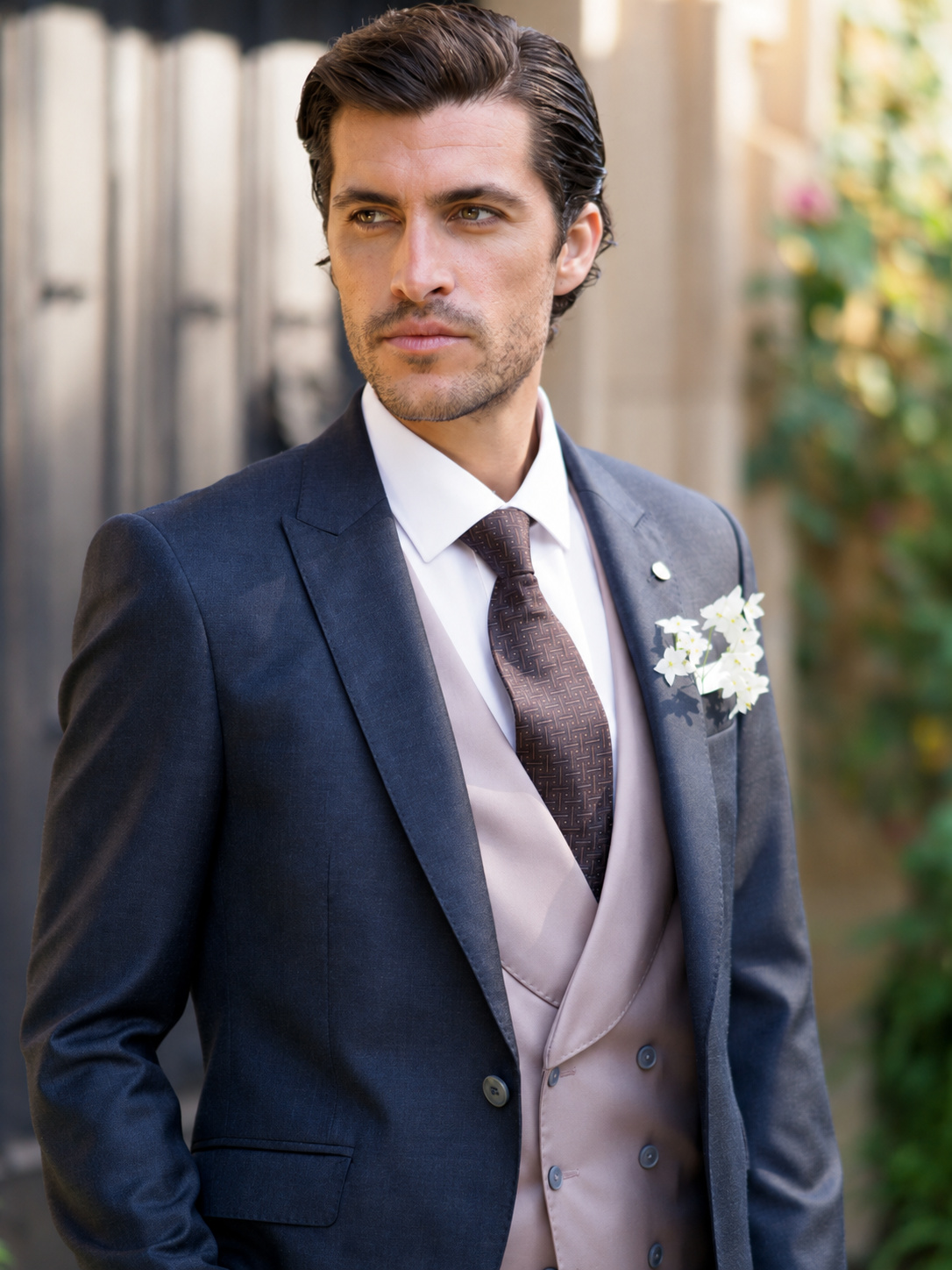 Look de novio con traje azul grisáceo y chaleco rosado
