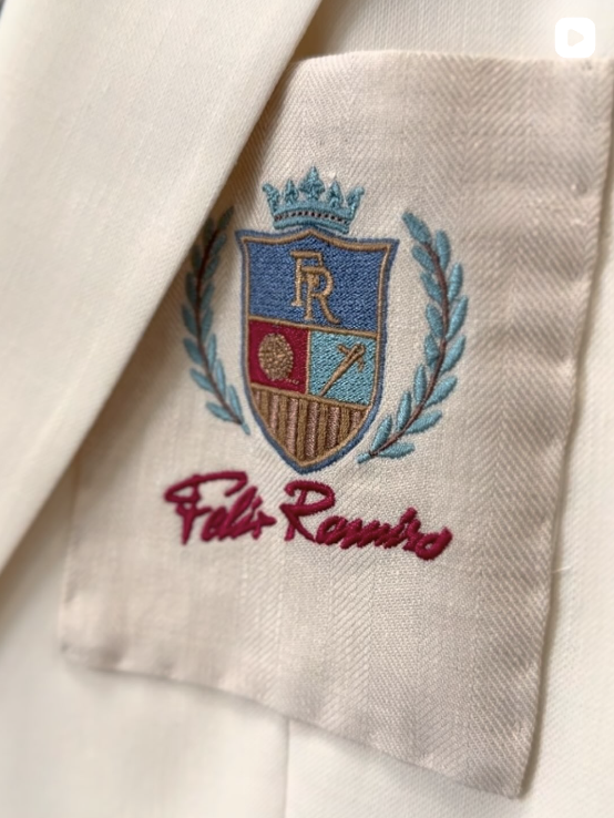 Detalle bordado de la firma Félix Ramiro sobre un tejido marfil